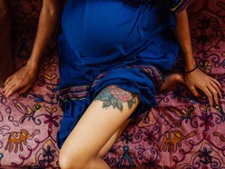 pregnant woman with rose tattoo on her thigh