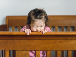 A baby standing in a crib awake
